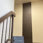 塾の入口から見上げる落ち着いた階段と案内板